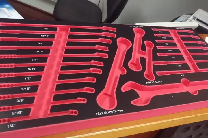 Red and black shadow foam toolbox insert with a labelled pocket per spanner